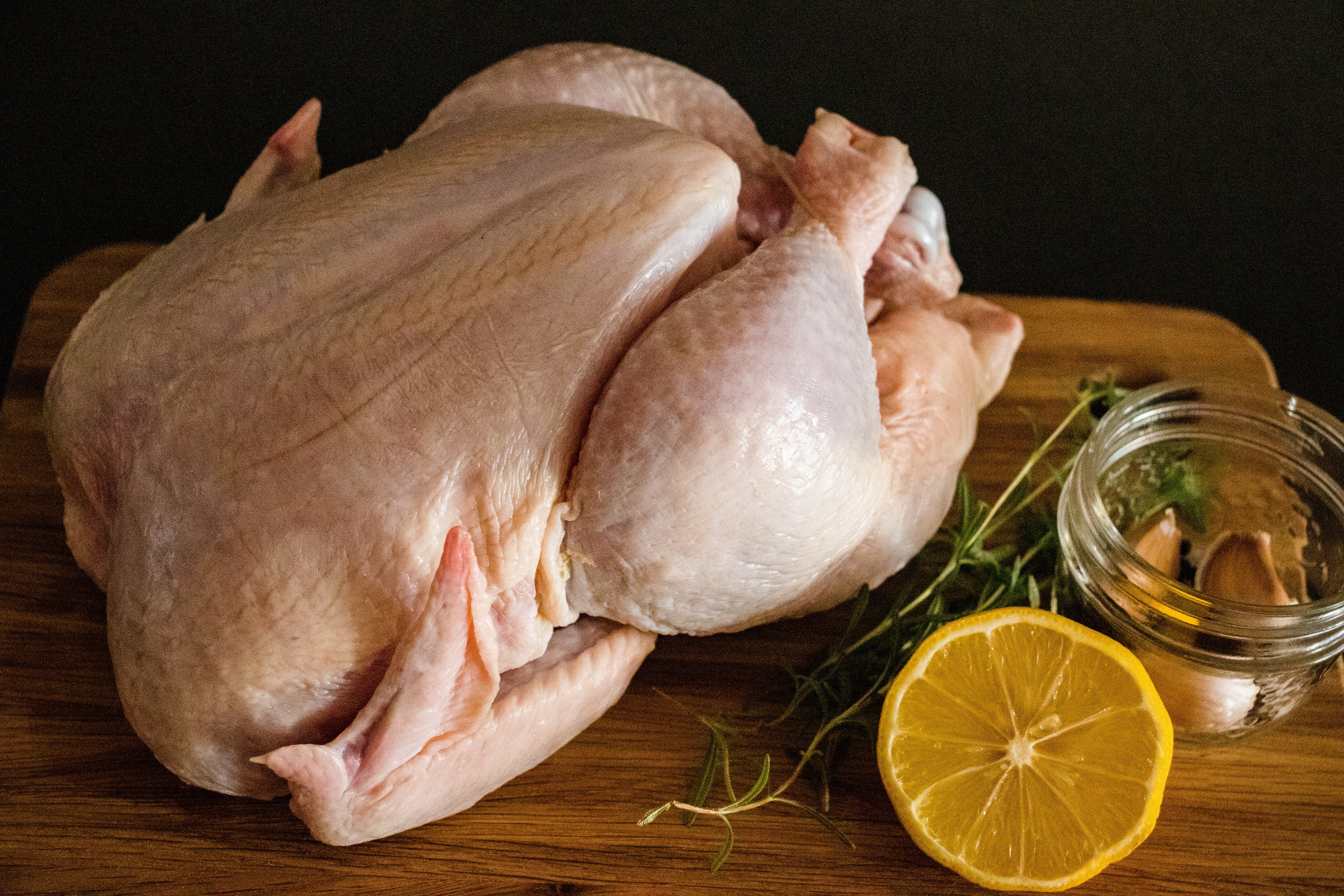 Ganzes Huhn Ganzes Huhn auf dem Tisch mit GEwürzen